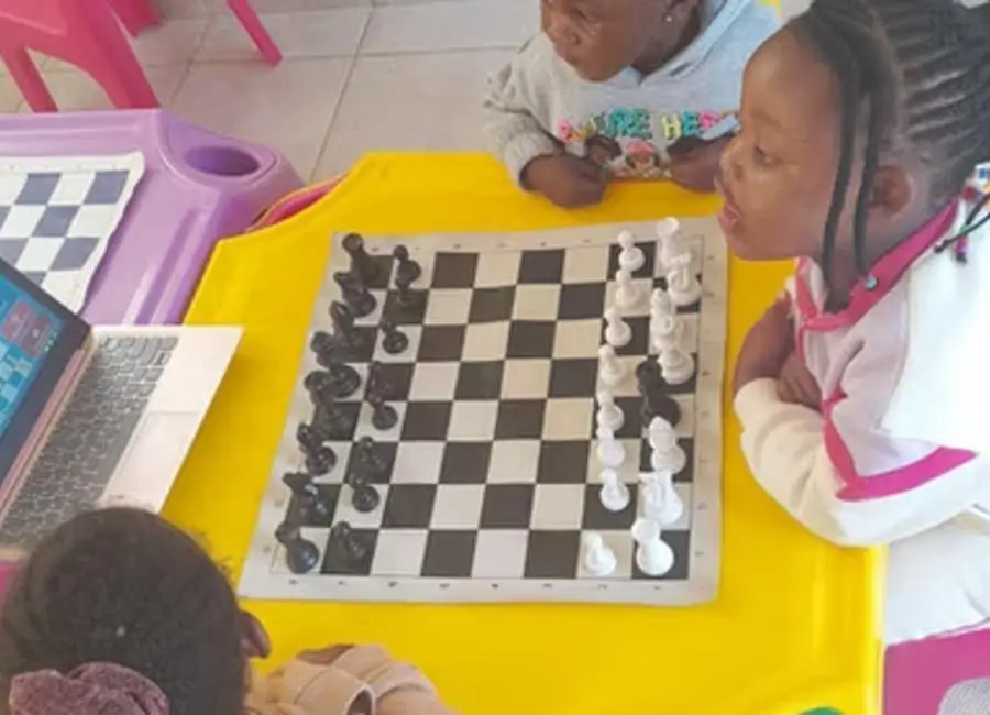 A child learning to play chess at Waterfall Kids Academy